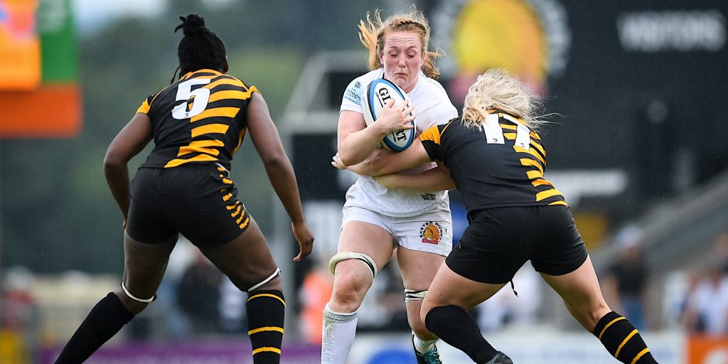 Welsh rugby player Abbie Fleming holds a rugby ball as she is tackled