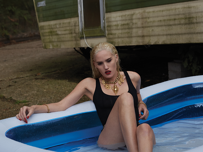 A women in a swim suit is sitting in a paddling pool