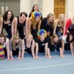 girls in colourful wigs are a human pyramid