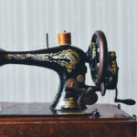 black and gold sewing machine on wooden table