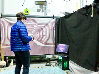 Man standing in front of a green screen using a VR headset