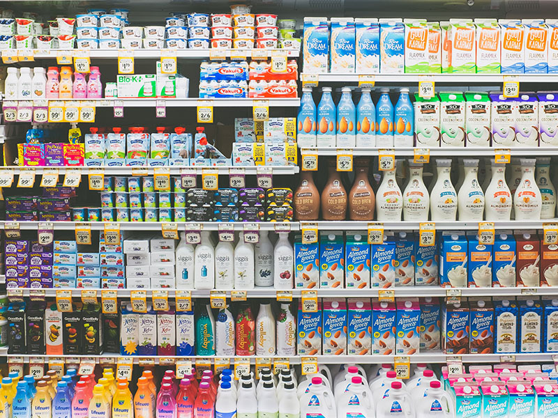 A photo of a supermarket fridge with no doors filled with refrigerated drinks.