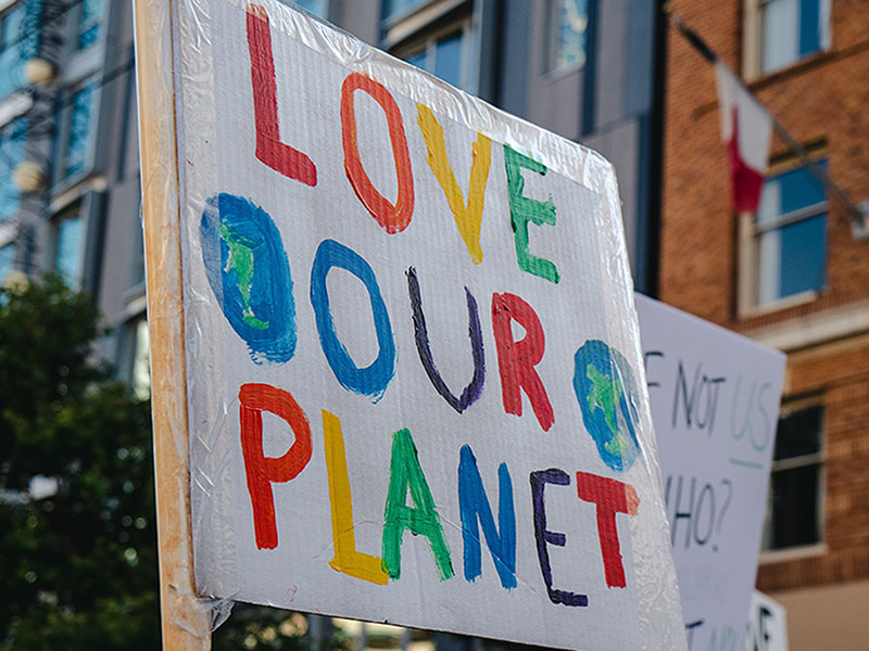 A colourful protest banner that reads 'Love Our Planet'. 