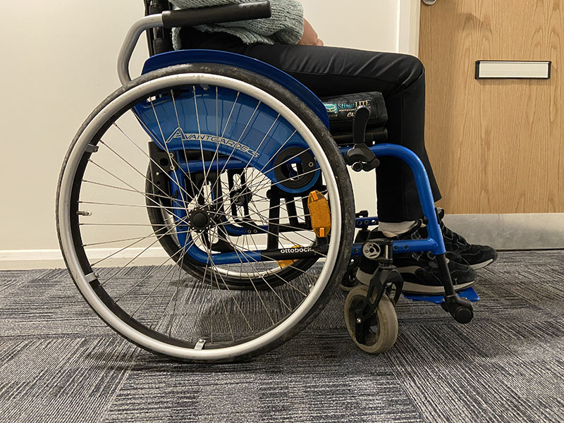 Person sitting on a blue wheelchair