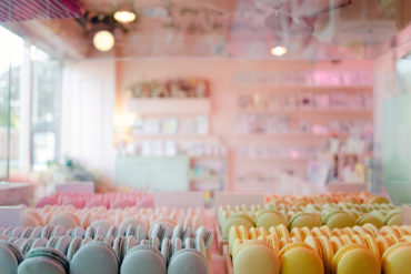 Pastel coloured macarons with the shop in the background