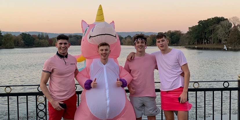 Alex in unicorn costume posing with friends at Roath Lake