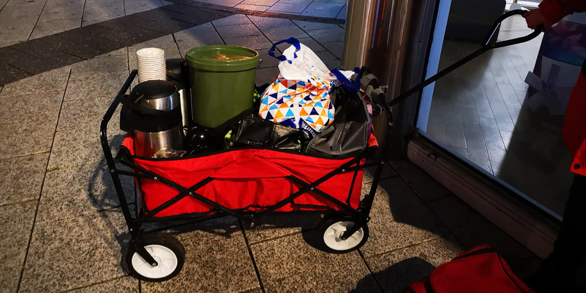 Red trolley filled with hot meals and drinks to feed the homeless