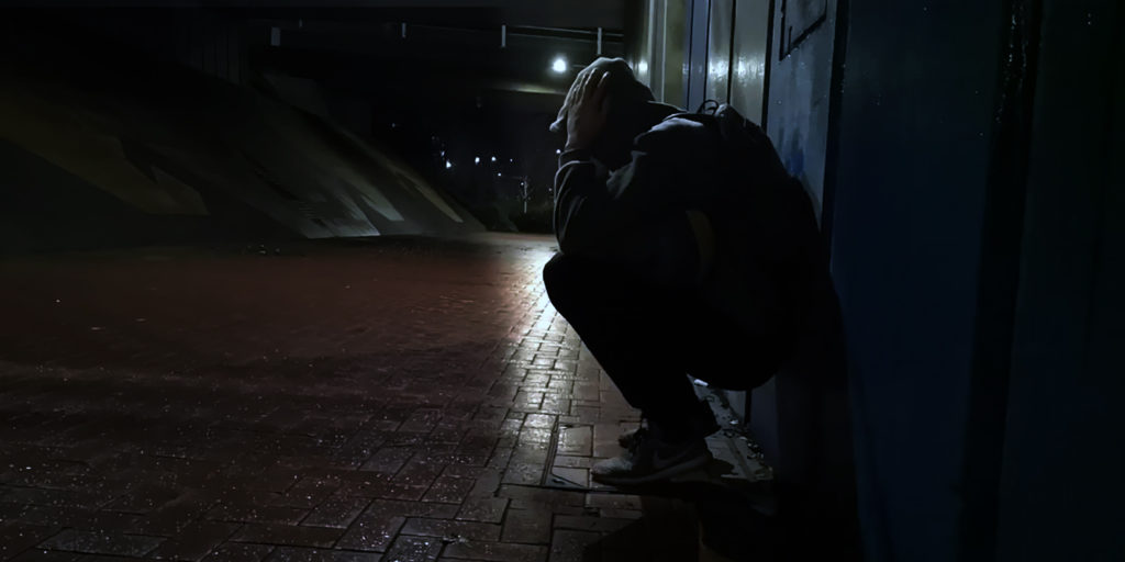 young boy under a flyover with a backpack