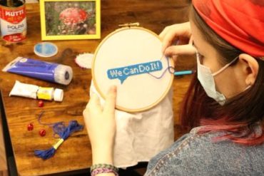 Woman embroidering "We can do it"