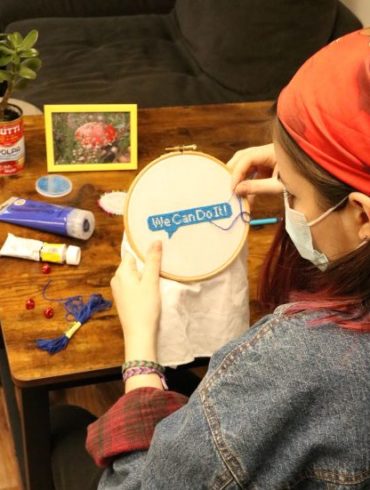 Woman embroidering "We can do it"