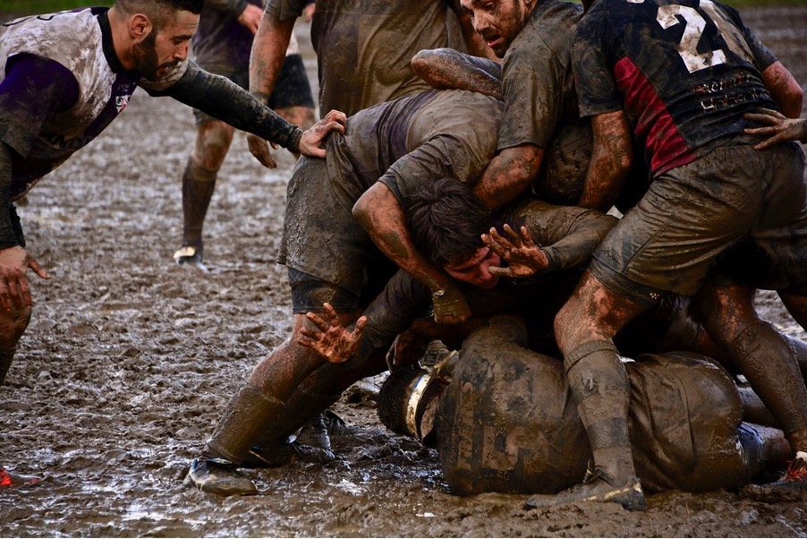 men playing rugby in mud at sports club