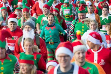 People dressed as Santa Claus, elves, and reindeer participating in the Santa and Elf Dash in 2018