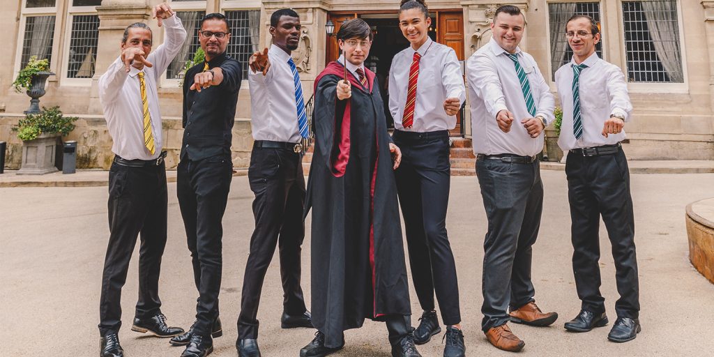 A group of men dressed in Harry Potter robes and uniforms