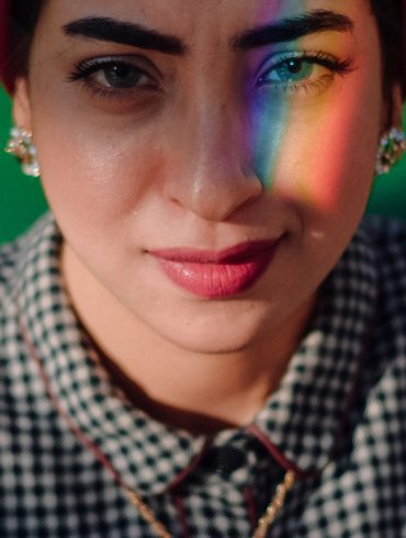 A woman with a rainbow over her left eye