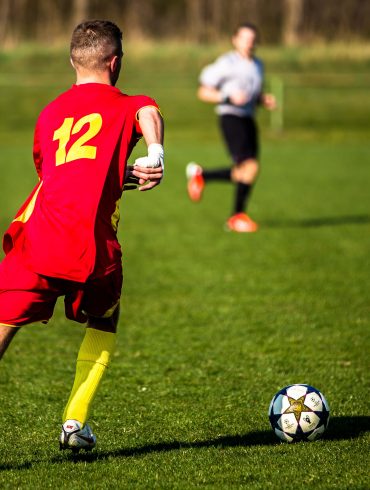 Men in red and blue play football