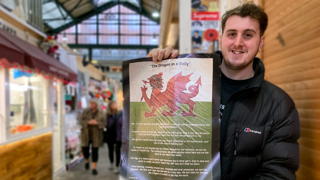 Poet Cal Ellis stands holding a copy of his poem 'The Dragon in a Bally'