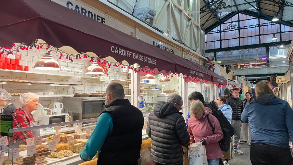 The photo shows customers waiting at Cardiff Bakestones to buy Welsh cakes 