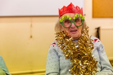 An old lady celebrates Christmas with her community.