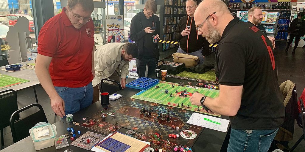 Two men playing the board game, Blood Bowl, at the Foodbowl charity tournament raising money for food banks