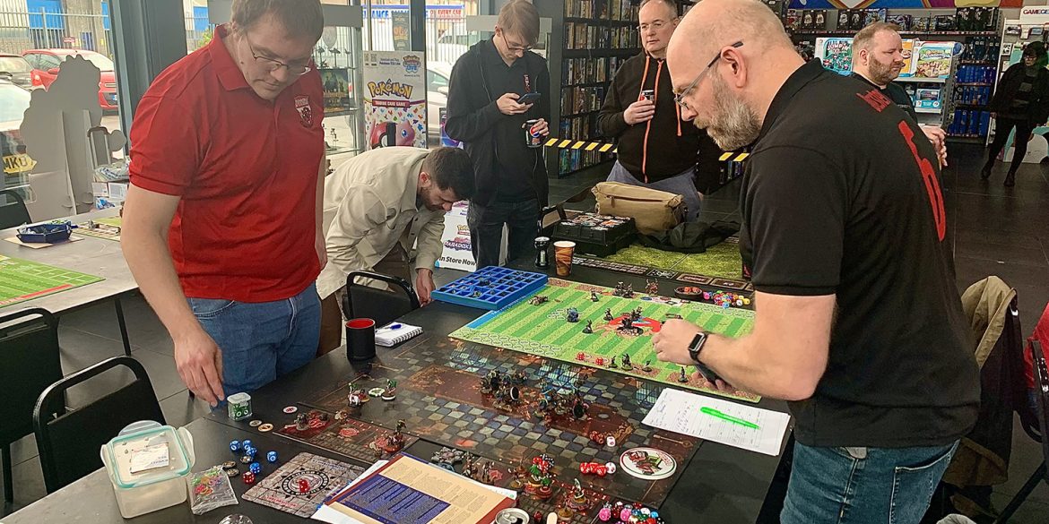 Two men playing the board game, Blood Bowl, at the Foodbowl charity tournament