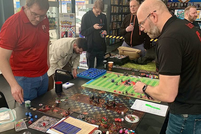 Two men playing the board game, Blood Bowl, at the Foodbowl charity tournament