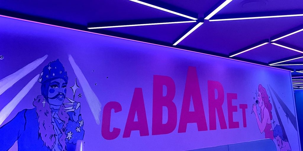 cabaret venue in cardiff, a sign that says cabaret with two drawings of drag artists on either side