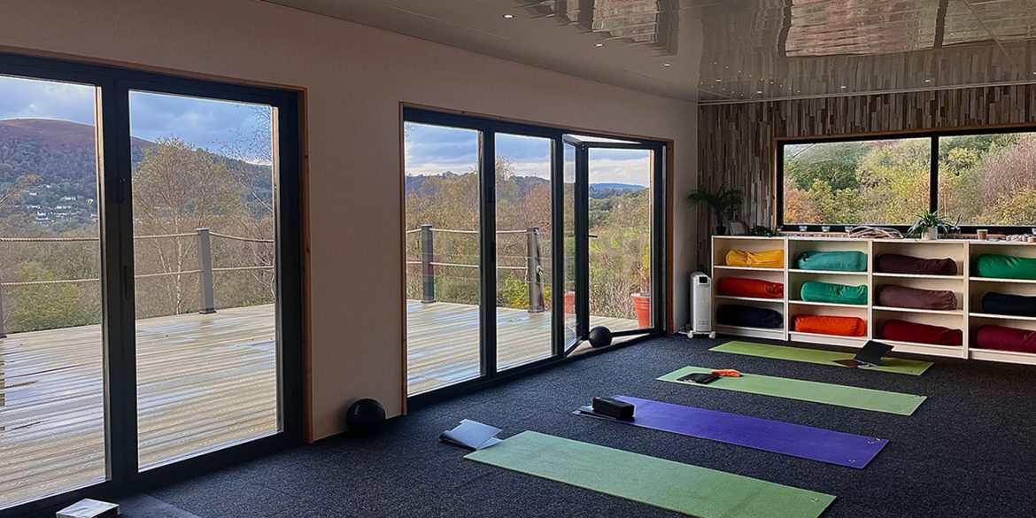 Sleep retreat set up at mountain view yoga wellness studio with mats laid on floor.