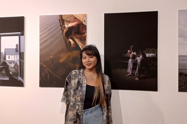 girl standing in from of wall with photos