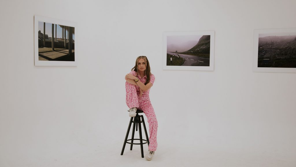 emerging Welsh photographer with her work at an exhibition
