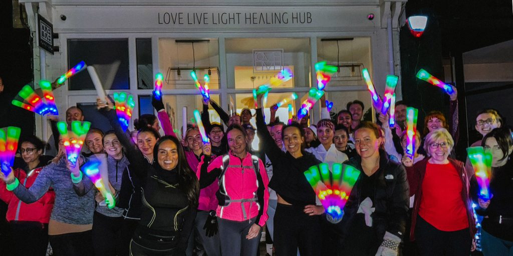 Group of smiling people in run kit holding glow sticks as they change Wales drinking culture
