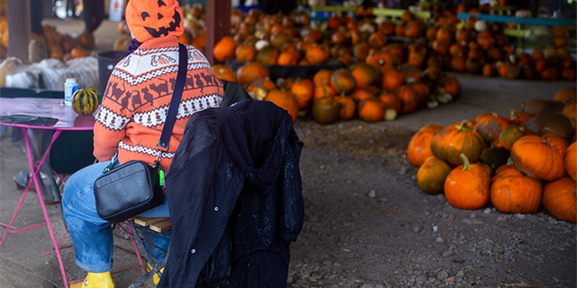 A woman in an orange Halloween jumper and pumpkin beret at Clearwell Farm