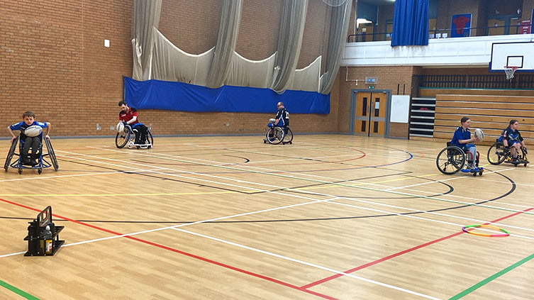 The wheelchair rugby team training in a sports hall 