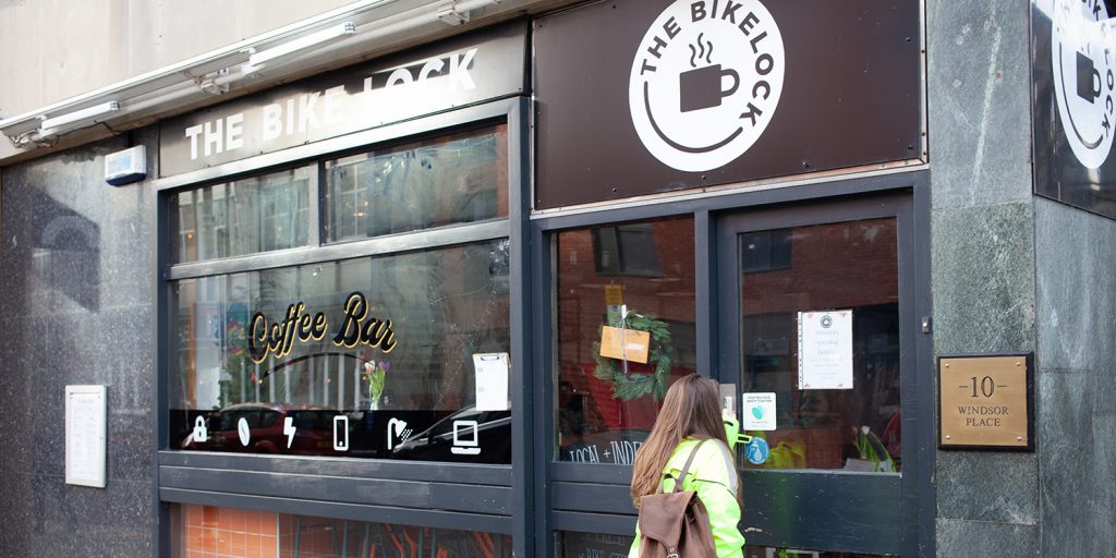 A photo outside the Bike Lock Cafe, Bar and Bike Storage with a customer entering