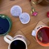 A variety of coffee cups and tea bags are on a table