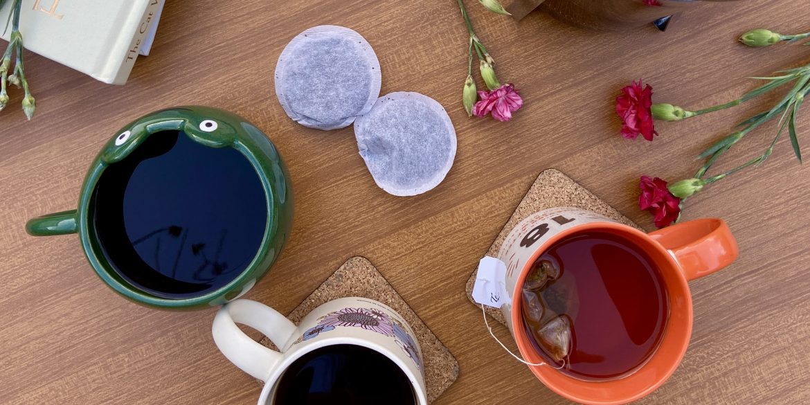 A variety of coffee cups and tea bags are on a table