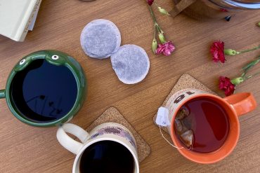 A variety of coffee cups and tea bags are on a table