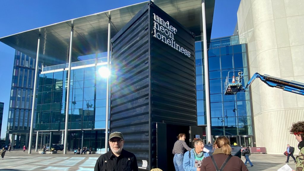 Mark James stands outside his installation Under Neon Loneliness