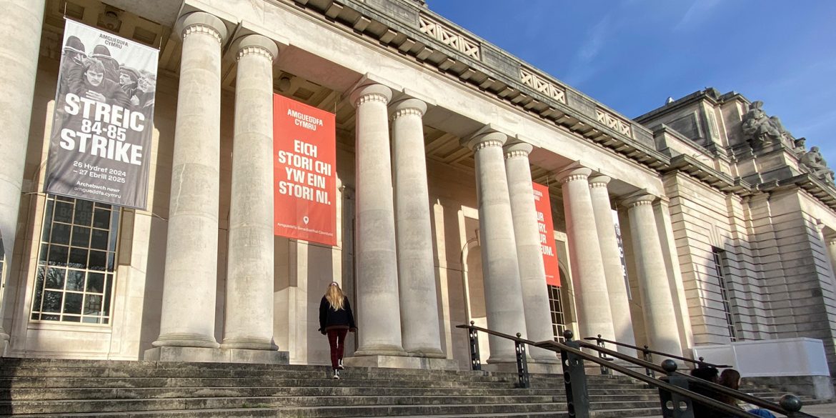 A visitor enters National Museum Cardiff on a sunny day