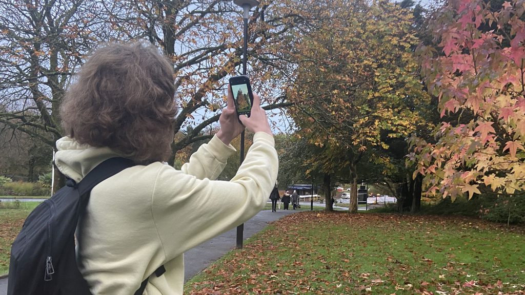 Steffan taking a picture of a tree with autumnally coloured leaves. As well as astrophotography, he enjoys photographing nature
