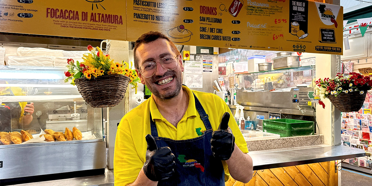 Franco, smiles, standing in front of his Italian Streed Food stall.