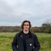 Young Welsh Musician stands in front of a field