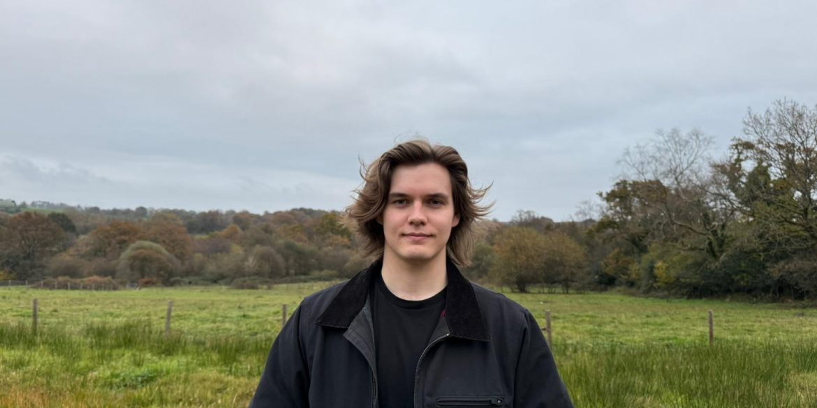 Young Welsh Musician stands in front of a field