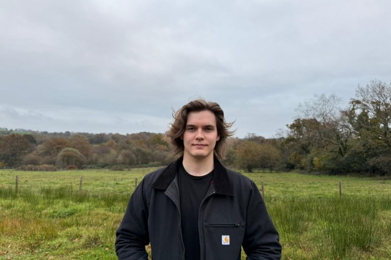 Young Welsh Musician stands in front of a field