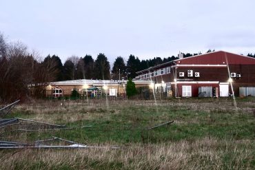 The old Michaelston College site, showing fencing all over the ground and the children's centre in the distance.