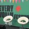 Everywoman festival background and a set of four chairs with microphones lying on them