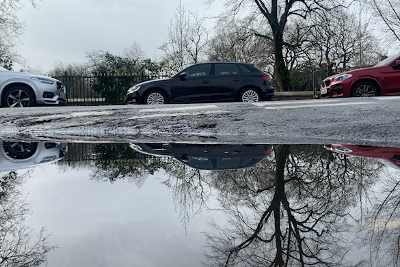 cars and sky reflected in a puddle