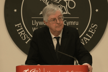 Mark Drakeford stands at a lectern.