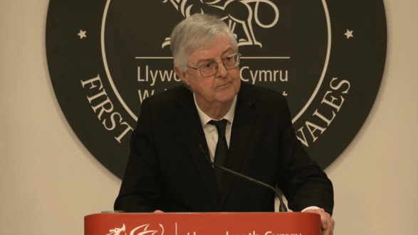 Mark Drakeford stands at a lectern.