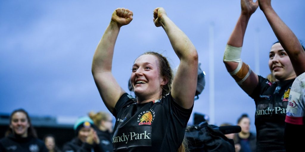 Welsh rugby player Abbie Fleming cheers in triumph with her hands held in the air