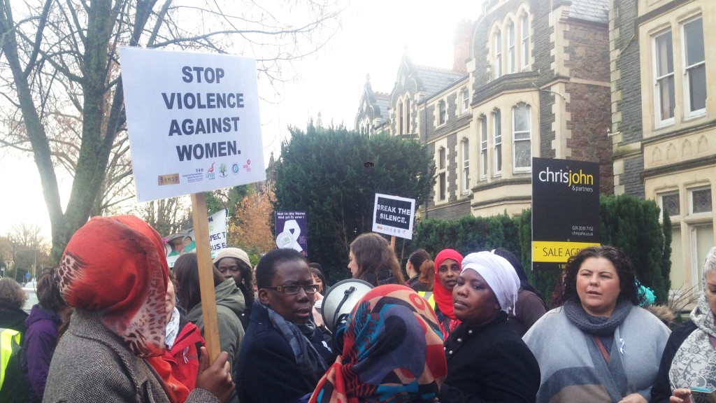 Women from different organisations holding up banners to commemorate White Ribbon Day 